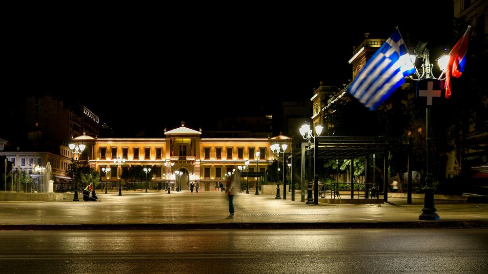 Nächtliche Szene in Athen mit griechischer Flagge