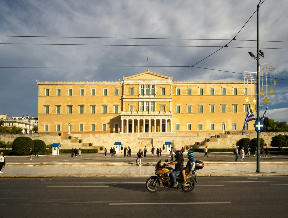 Der Syntagma-Platz in Athen mit dem griechischen Parlamentsgebäude, davor die Wachhäuschen der Evzonen und ein Laternenmast mit weihnachtlicher Sterndekoration