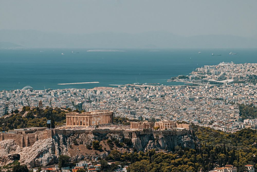 Blick über Athen mit der Akropolis und dem Meer im Hintergrund